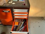 une armoire orange dont le tiroir est rempli de stylos et d'autres fournitures de bureau