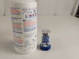 a bottle of liquid sitting next to a small cup