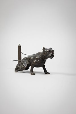 statue of a dog tied to a pole with a chain