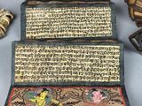 three pieces of chinese writing are sitting on a table next to other items