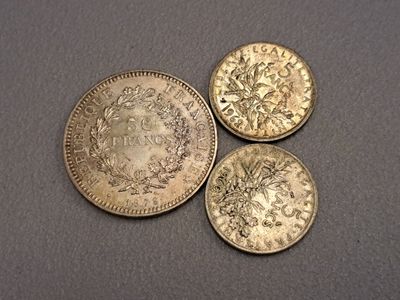 trois pièces d'or posées les unes à côté des autres sur une table