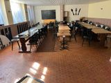 Il y a de nombreuses tables et chaises dans cette salle, avec un tableau noir accroché au mur.