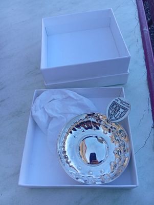 une assiette en argent dans une boîte blanche posée sur une table
