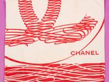 une écharpe rouge et blanche sur laquelle est inscrit le mot « Chanel »