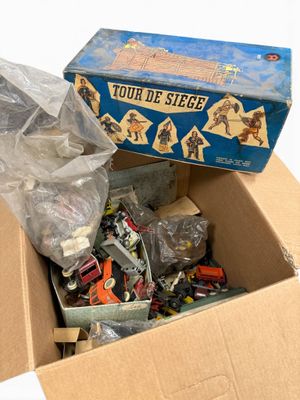 a cardboard box filled with assorted toys on a white surface