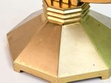 a gold and green candle holder on a white table