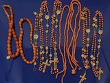 Plusieurs perles et croix orange sont disposées sur un fond bleu