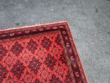a close up of a red rug on the ground