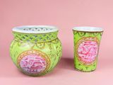 deux vases verts ornés de motifs roses sur fond rose