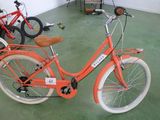 un vélo orange garé dans une pièce avec d'autres vélos