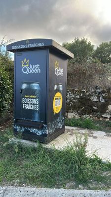 a trash can sitting on the side of the road