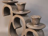 a sculpture of three cups and saucers sitting on a table