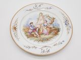 une assiette sur laquelle est représentée une femme et deux enfants