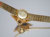 a close up of a gold watch on a gold bracelet