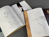 a book with a drawing of a man in a hat and a book with a drawing of a man in a hat