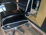 a black office chair sitting in front of a mirror