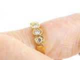 a person holding a gold ring with three diamonds on it