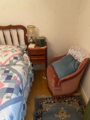un lit et une chaise dans une petite pièce