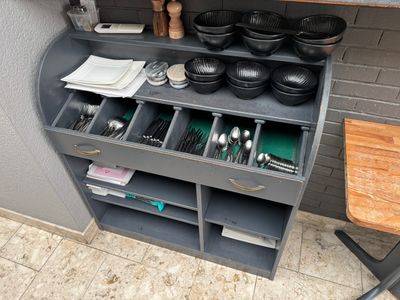 a kitchen with a counter with a lot of utensils and pans on it