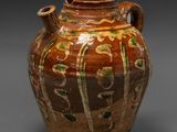 a brown vase with green and yellow designs on it