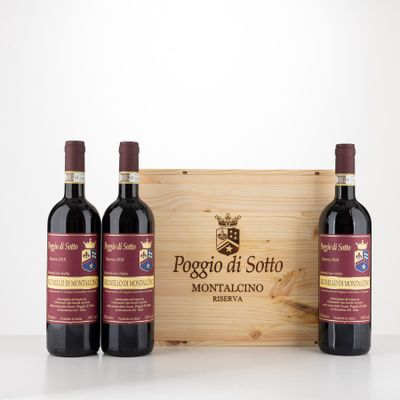 three bottles of red wine in front of a wooden box