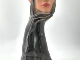 sculpture of a woman ' s head with her hands on her face