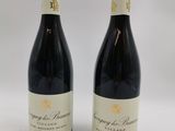 deux bouteilles de vin posées l'une à côté de l'autre sur une surface blanche