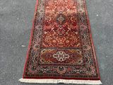 Un tapis rouge est posé par terre à côté d'une chaise bleue.