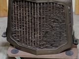 un radiateur à l'ancienne posé sur un socle en bois