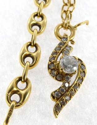 a close up of a pair of earrings on a white surface