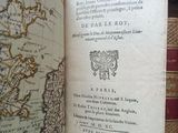an open book with a map on it in front of a bookshelf