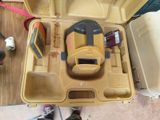 une mallette à outils jaune, contenant des outils, posée par terre