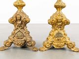 pair of antique brass candlesticks with ornate designs on each side