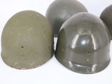 three helmets sitting on top of each other on a white surface