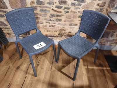 two blue chairs sitting next to each other on a wooden floor