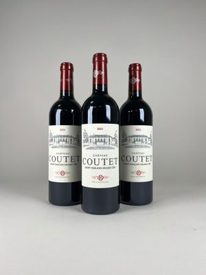 three bottles of red wine sitting next to each other on a table