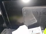 a black oven with the door open and a newspaper on the counter