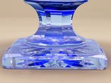 a blue glass candle holder on a table