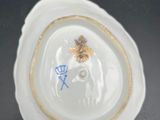 a small white bowl with a gold decoration on it