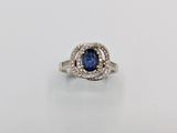 a blue sapphire and diamond ring on a white surface