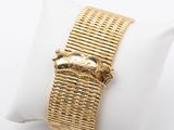 an image of a close up of a gold bracelet on a white pillow