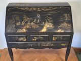 a black and gold painted desk with drawers on it