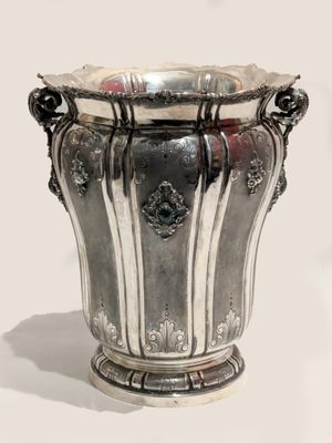 a silver vase that is sitting on a table