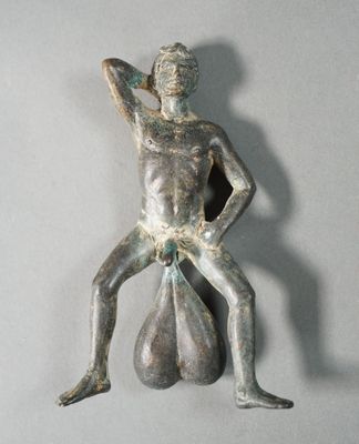 statue d'un homme tenant un sac de sable sur une surface grise