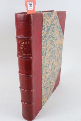 un vieux livre à la couverture rouge posé sur une table blanche