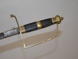 a close up of a sword on a white surface