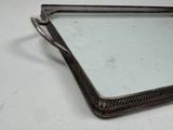 a silver tray with a mirror on it on a table