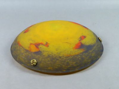 une photo d'un objet jaune et rouge posé sur une surface blanche