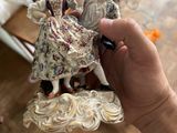 a person holding a figurine in their hand