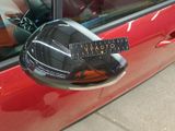 mirror of a red car with a sticker on the side of it